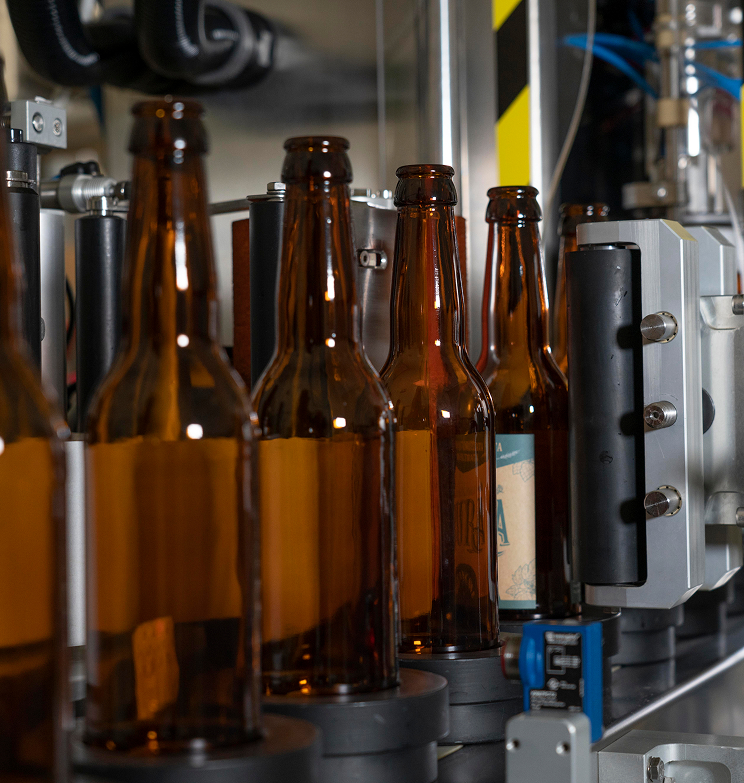 Primo piano dell’etichettatura automatica delle nostre bottiglie di birra artigianale.